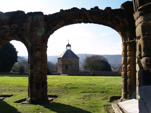 The 16th century dovecot framed in the ruins of Guisborough Priory entrance on a bright sunny morning.