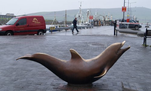 Sculpture of Fungie the dolphin who lives in Dingle Harbour to the delight of local business and thousands of tourists - Dingle Town & Harbour, Dingle Peninsular, Co. Kerry, West of Ireland