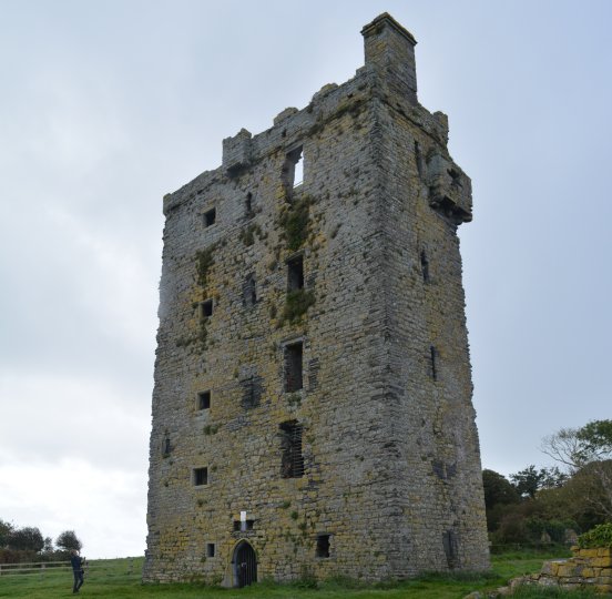 The tall multi-story ruined building of medieval Carrigaholt Castle, Co. Clare, West of Ireland