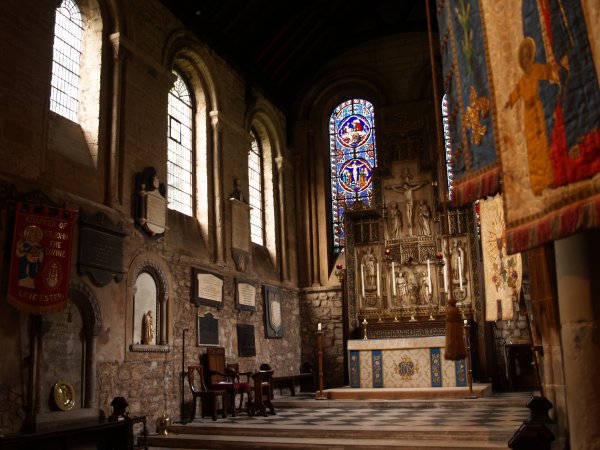The High Altar with Reredos and replacement Norman windows in the 12th century Chancel. The internal architecture of St Mary de Castro Church, City of Leicester, England, English Midlands