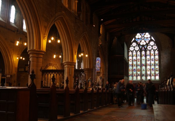 Looking east down the south Trinity Aisle and its fine east window, with the nave and chancel on the left (the bucket is now in position to catch the leaks!). The internal architecture of St Mary de Castro Church, City of Leicester, England, English Midlands