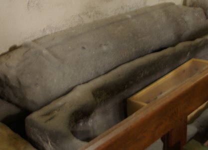 The Early English Gothic stone coffin with a cross carved on the lid.