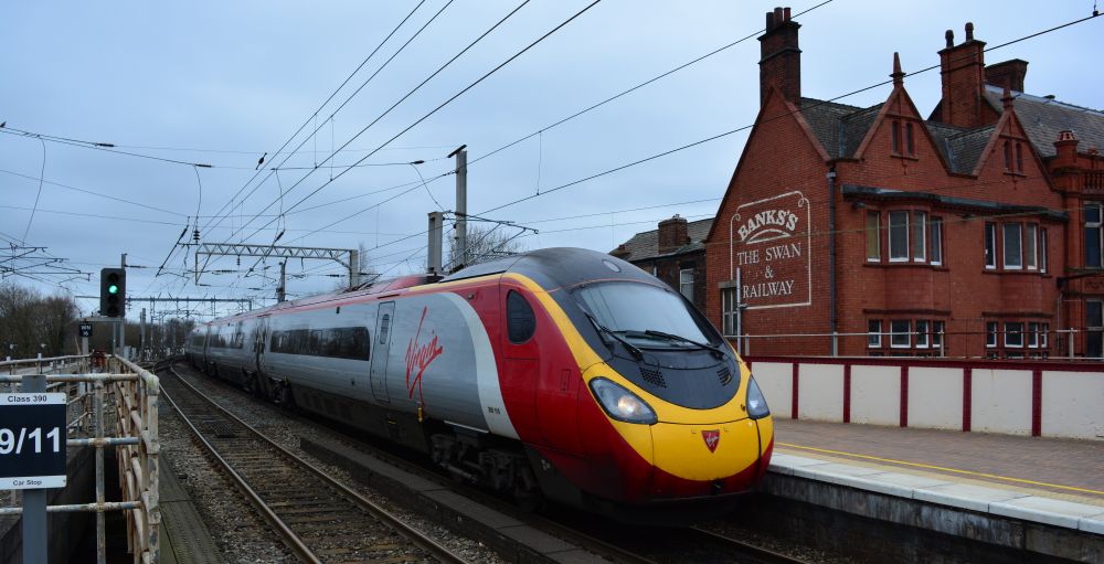 trainspotting at Wigan North Western Station Class 390 EMU train entering Wigan North Western station with a Glasgow Central to London Euston Virgin train service. The pub Bank's THE SWAN & RAILWAY.